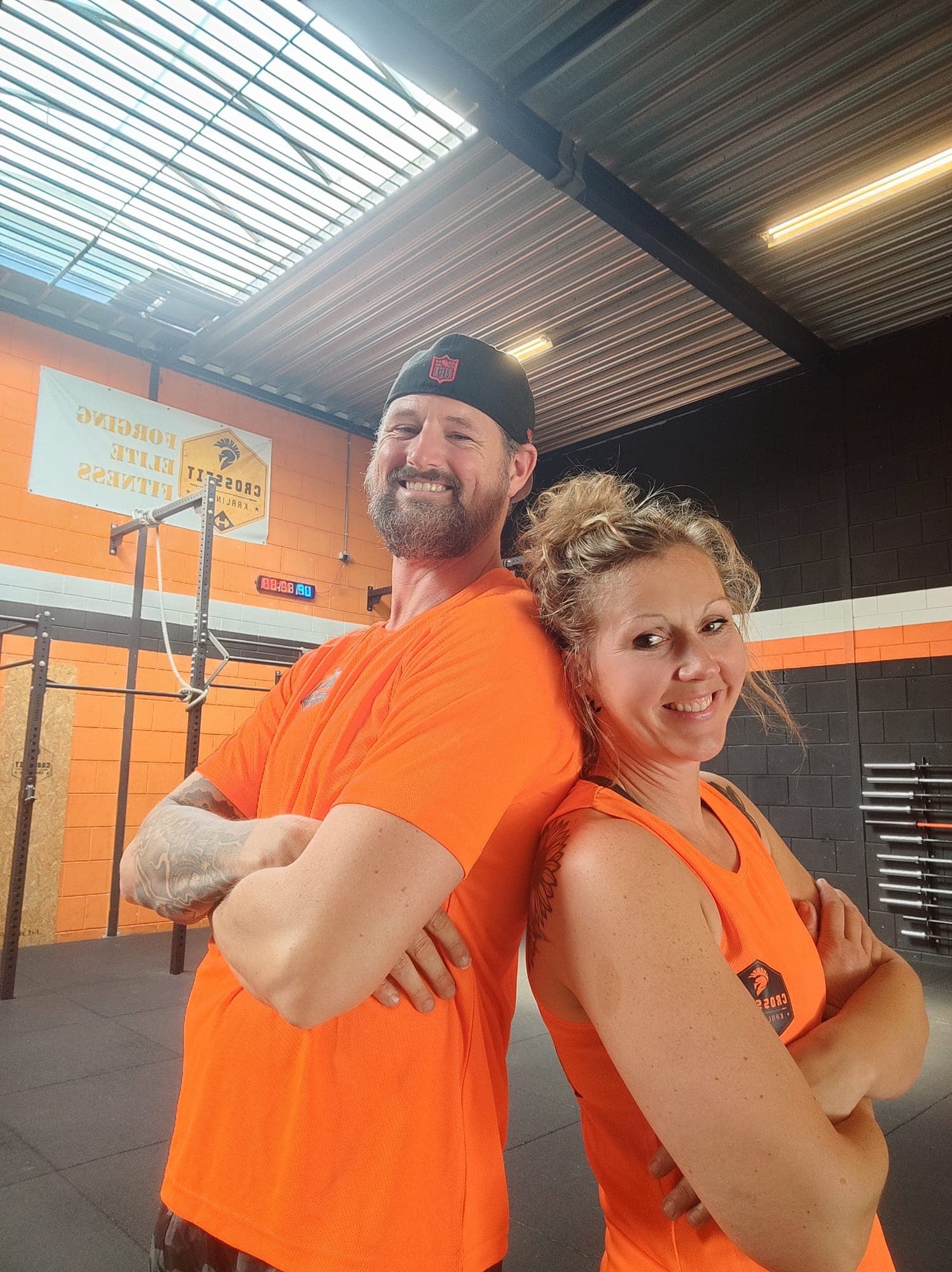 Coach en lid lachen samen voor de WOD
